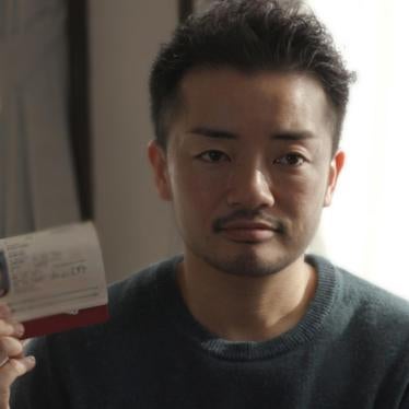 Fumino Sugiyama, a transgender man, holds his Japanese ID card, which reads “female,” at his home in Tokyo.