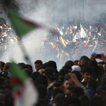 Protesters march in a cloud of tear gas fired by riot police as they denounce President Abdelaziz Bouteflika's bid for a fifth term, March 1, 2019.