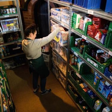 A volunteer at a Trussell Trust food bank prepares food parcels from their stores of donated food, toiletries and other items. London, United Kingdom. 