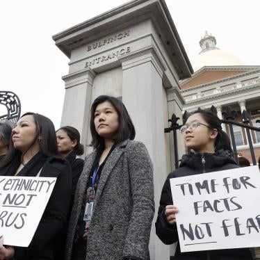 Jessica Wong, of Fall River, Mass., front left, Jenny Chiang, of Medford, Mass., center, and Sheila Vo, of Boston, from the state's Asian American Commission, stand together during a protest, Thursday, March 12, 2020