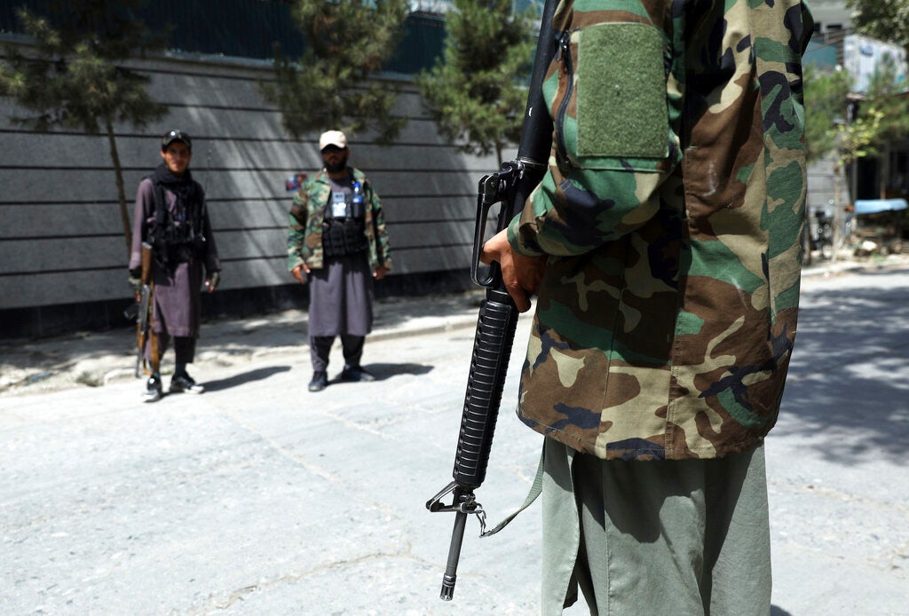 Des combattants talibans, l’arme au poing, surveillaient une rue dans le quartier de Wazir Akbar Khan à Kaboul, en Afghanistan, le 22 août 2021. 