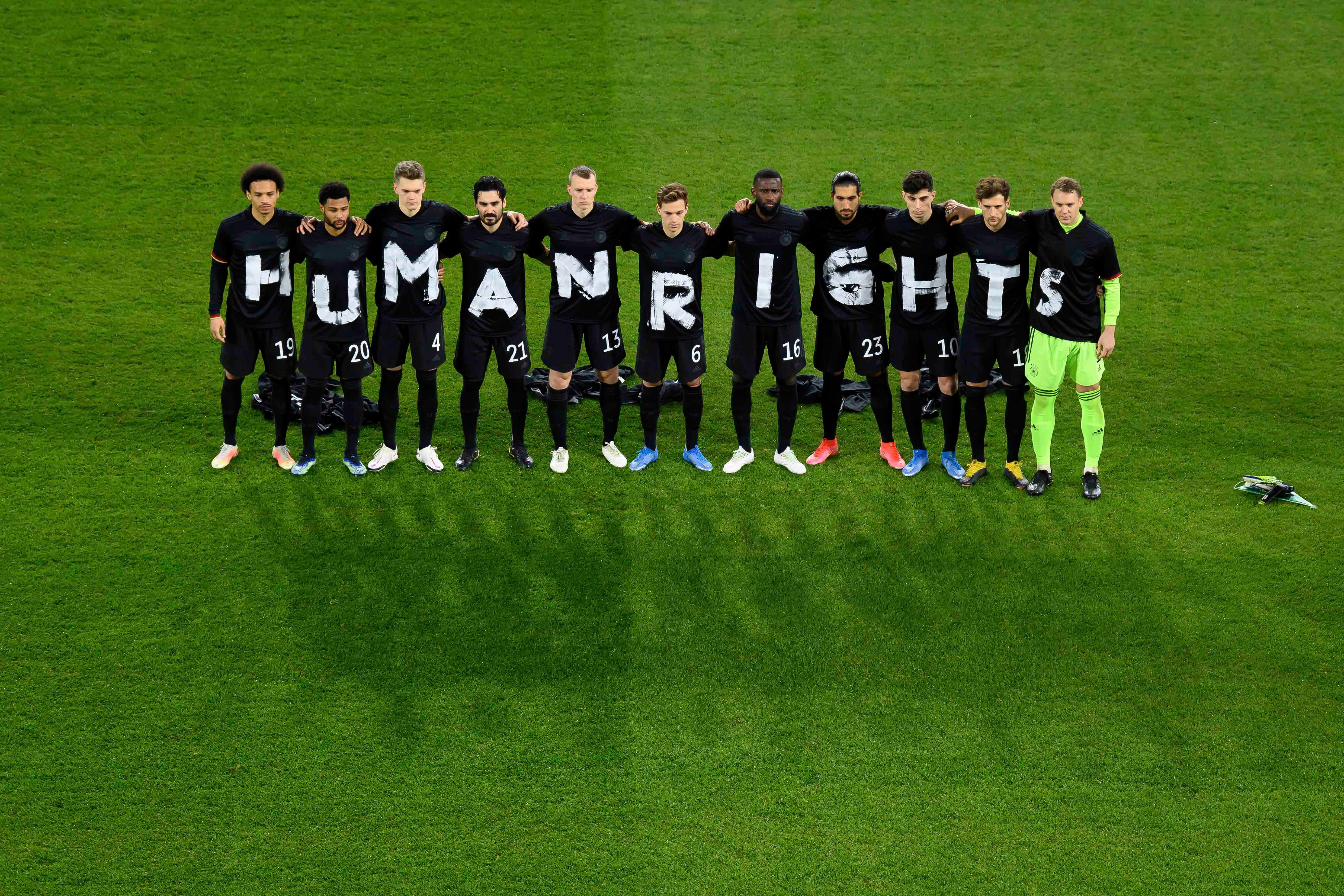 لاعبو الفريق الألماني لكرة القدم في مباراة تصفيات كأس العالم ما إيسلندا يرتدون قمصانا كتب عليها "حقوق الإنسان" بالإنغليزية في 25 مارس/آذار 2021، دويدسبورغ، ألمانيا. 