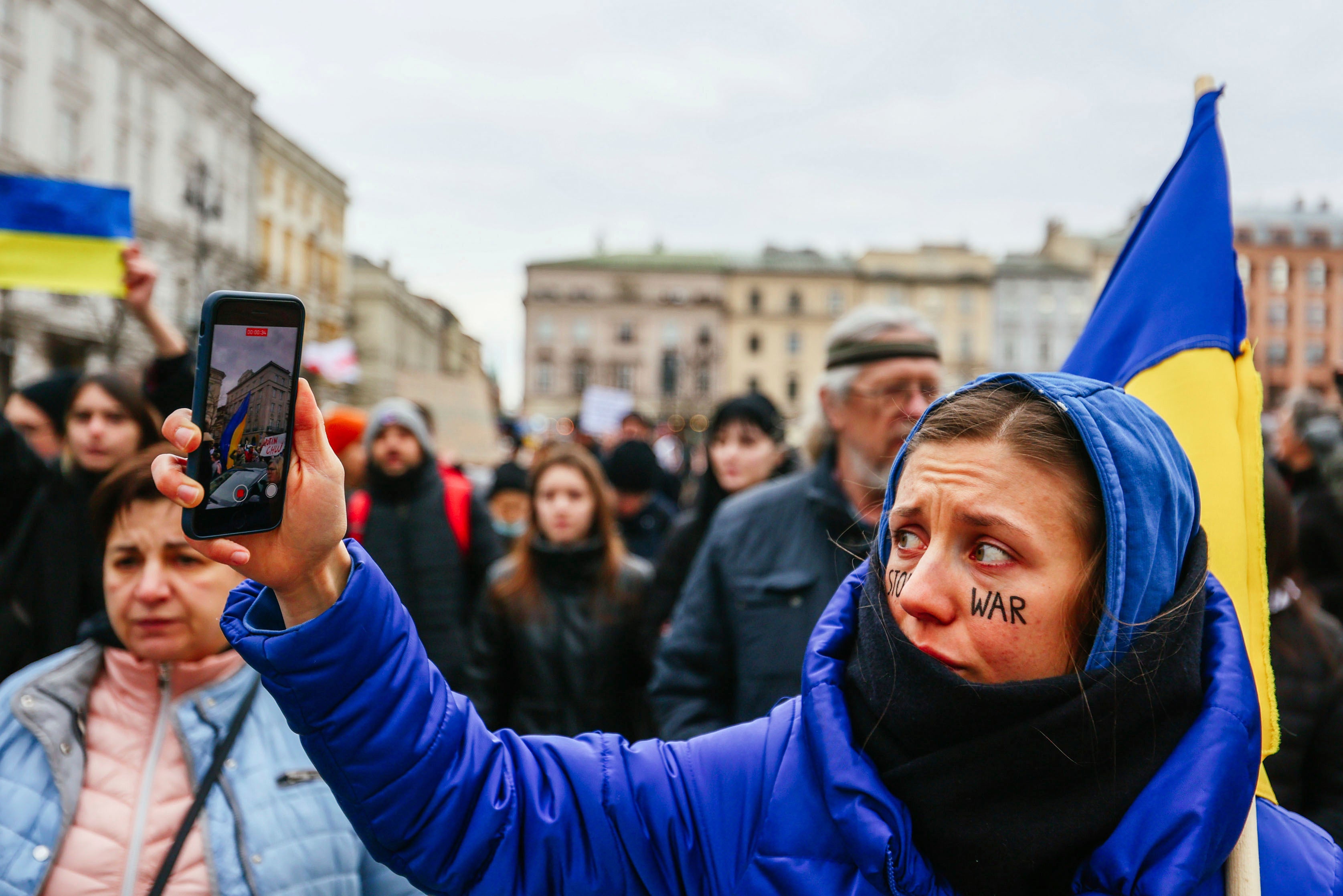 Протестующая ведет прямую видеотрансляцию демонстрации с смартфона в Кракове, Польша, 27 февраля 2022 года. 