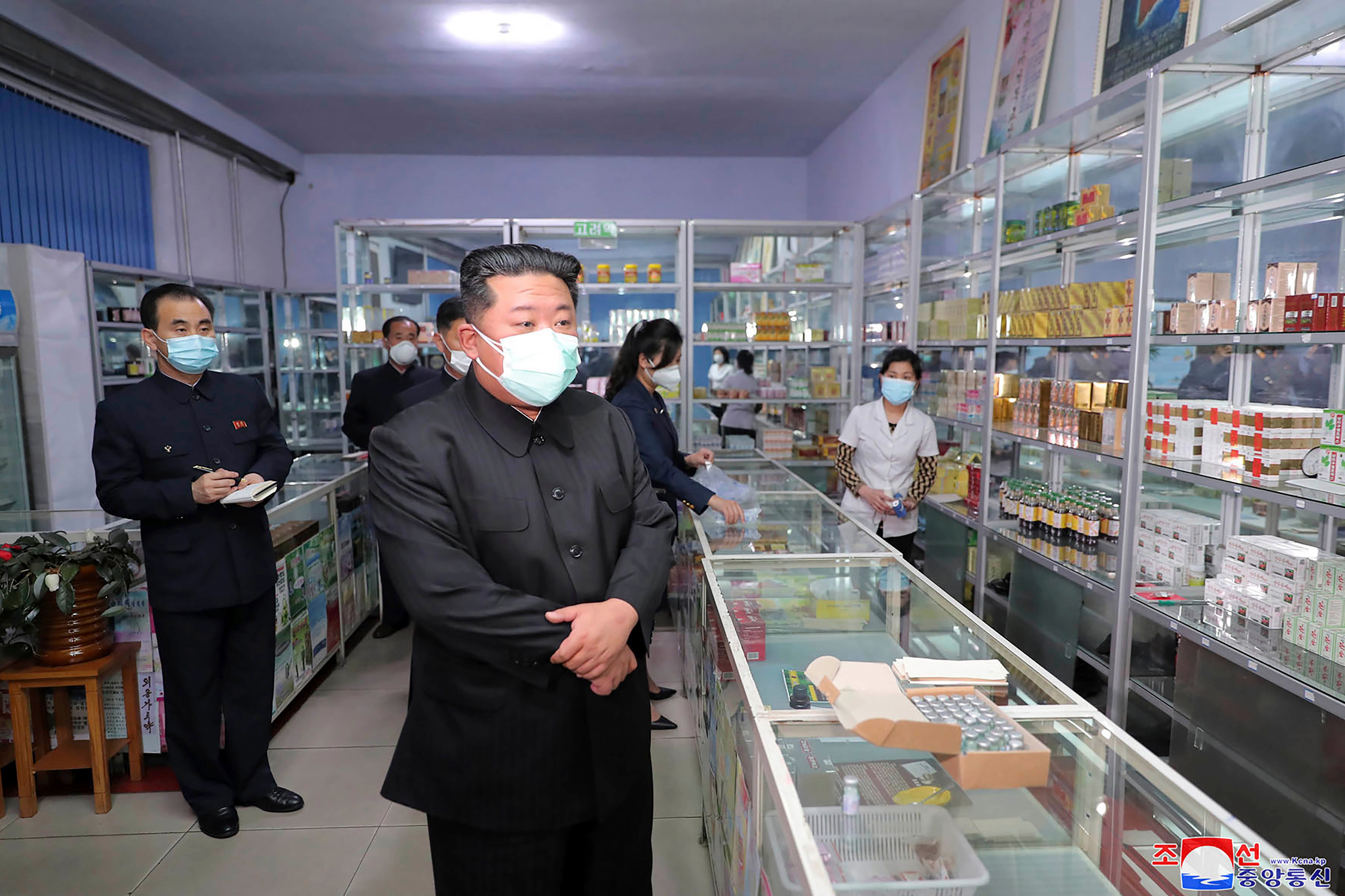 Kim Jong Un wearing a mask, during a visit to a pharmacy