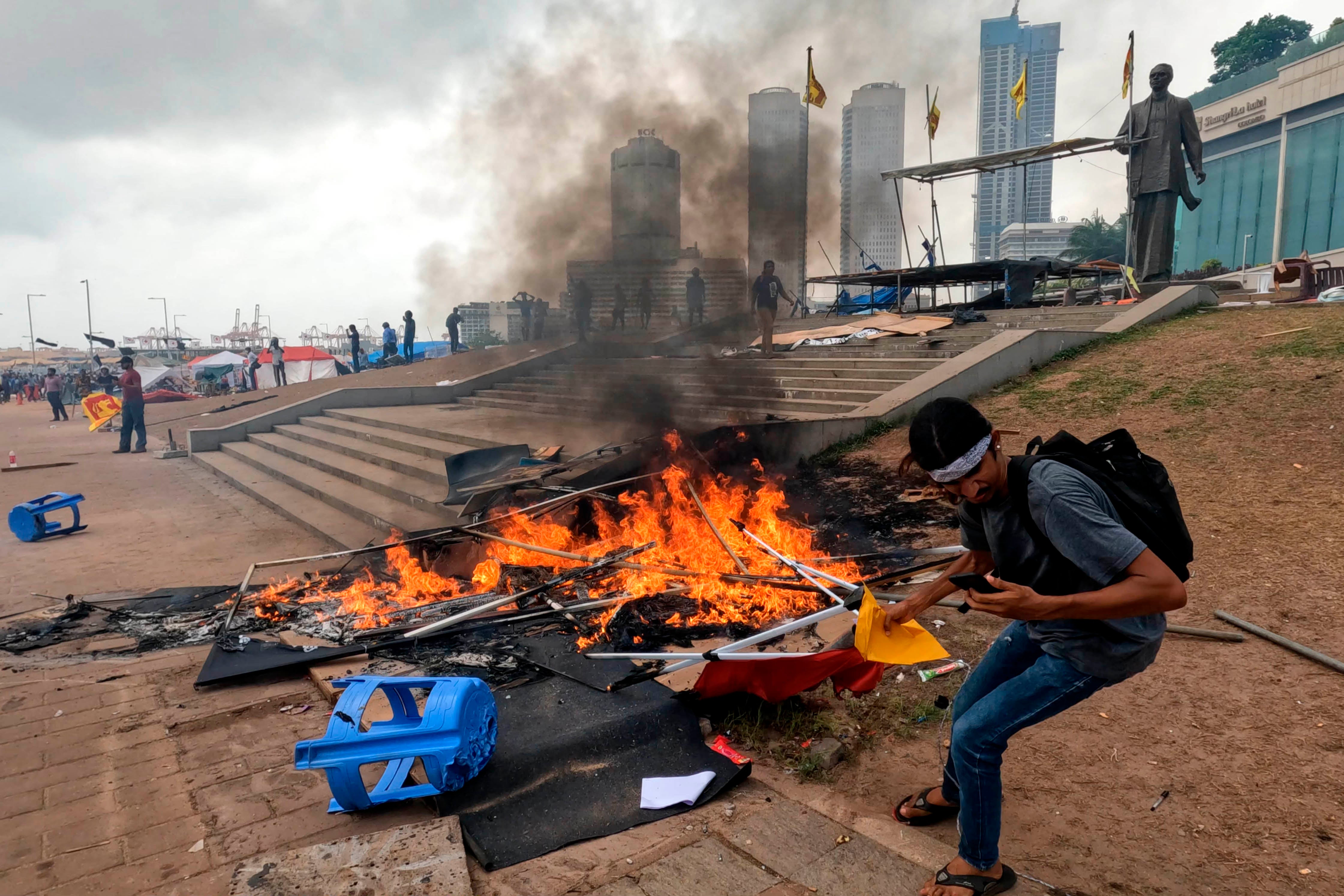一名斯里兰卡反政府示威者试图从被亲政府人士纵火的帐篷中抢救文件，斯里兰卡科伦坡加勒菲斯绿地，2022年5月9日。