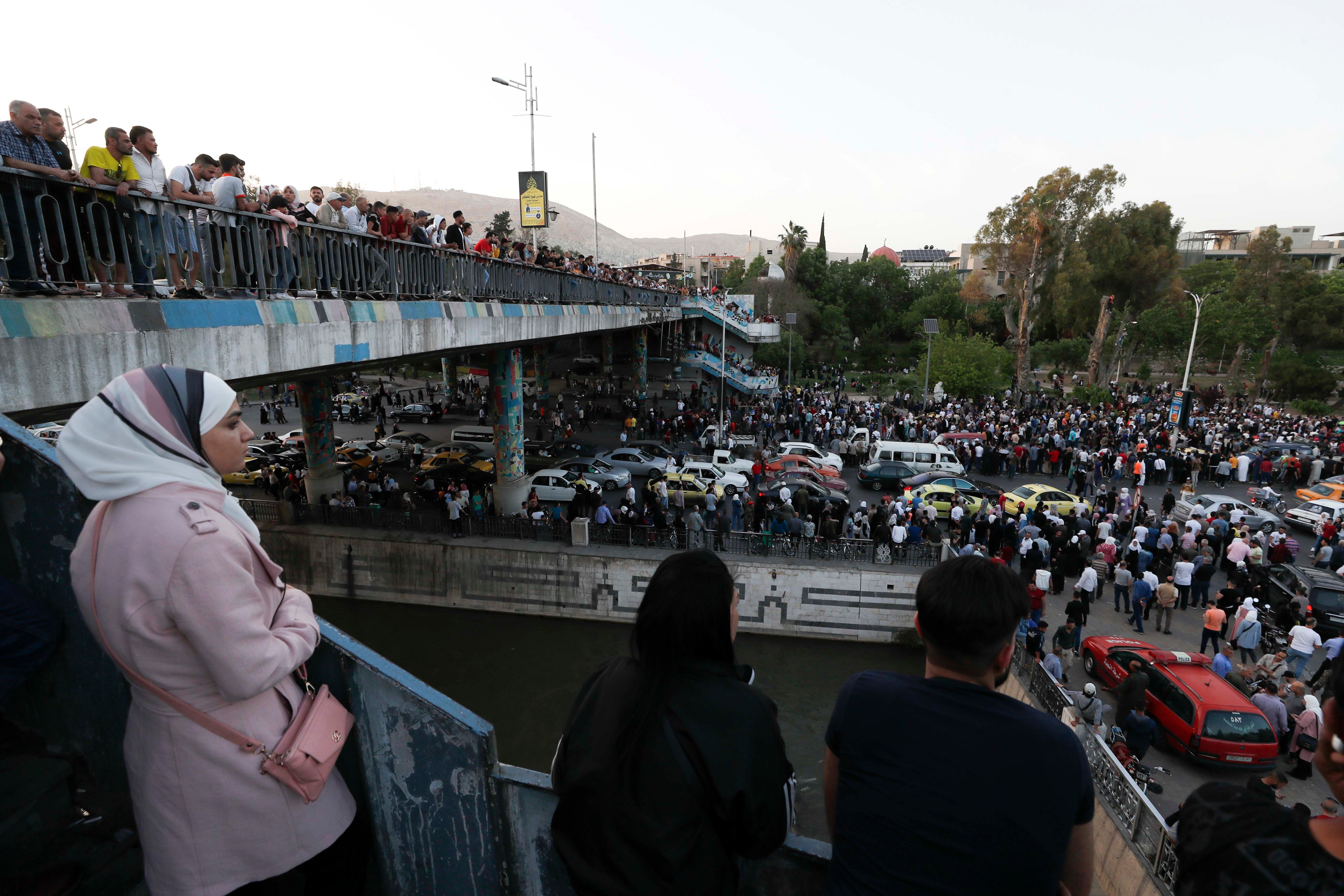 عشرات السوريين ينتظرون عند جسر الرئيس في دمشق أقارب يأملون بأن يكونوا من بين الذين أطلِق سراحهم من السجن في 3 مايو/أيار 2022.