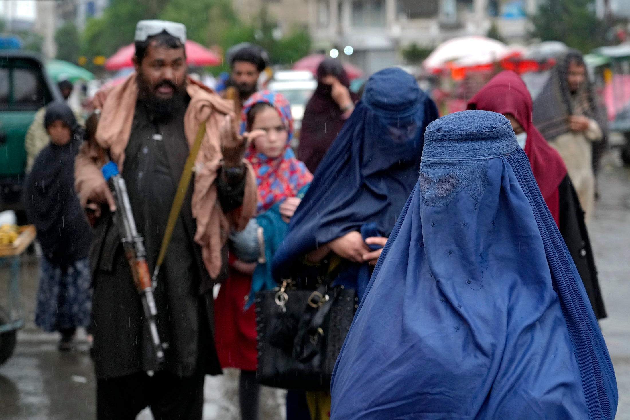 افغان ښځې په کابل کې د طالبانو د امنیتي ځواکونو په خوا کې په لاره روانې دې، افغانستان، د ۲۰۲۲ کال د می میاشت.
