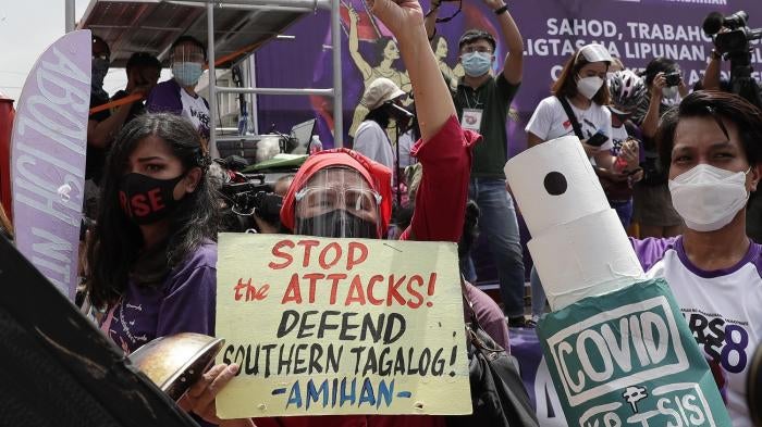 Protesters display slogans condemning the recent government attacks on activists during a rally near the Malacanang presidential palace on March 8, 2021 in Manila, Philippines.