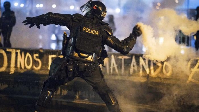 A member of ESMAD throws a tear gas grenade by hand at protesters on May 28, 2021 in Bogota, Colombia.