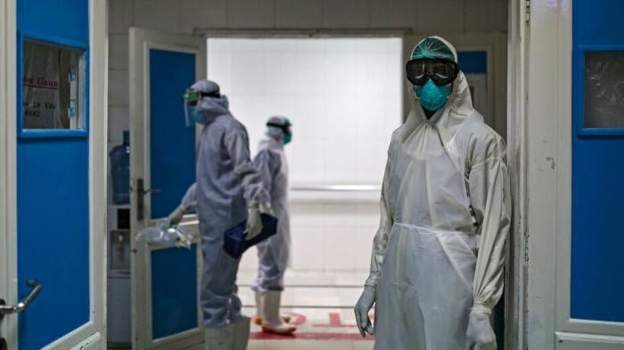 A medical worker wearing full protective gear stands at the gate of the intensive care unit of a hospital, where coronavirus (Covid-19) patients are treated in Sanaa, Yamen, on June 15, 2020.