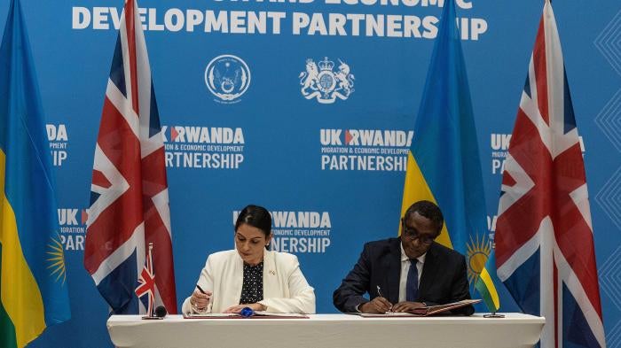 British Home Secretary Priti Patel (L), and Rwandan Minister of Foreign Affairs and International Cooperation Vincent Biruta sign an agreement