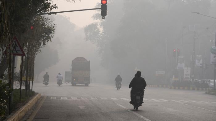 Vehicles and motorcyclists amid severe air pollution in Lahore, Pakistan, November 24, 2023.
