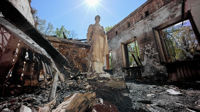 A statue stands amidst the ruins of a museum 