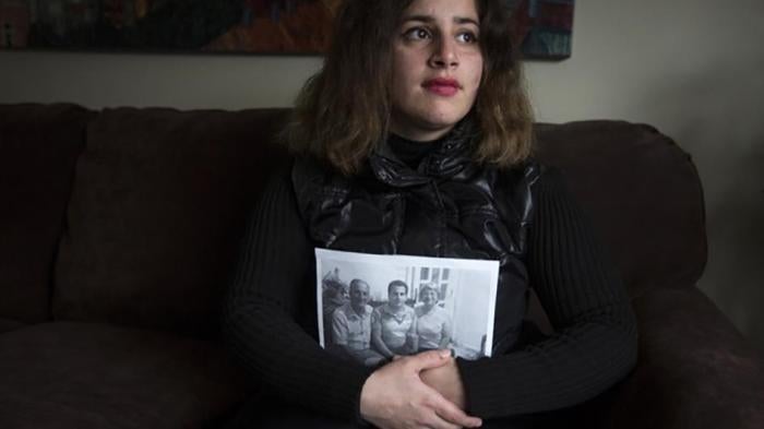 2015年11月22日在美国新泽西州奥克兰， 刚逃离叙利亚的难民桑迪怀抱着仍留在叙利亚的家人照片留影。