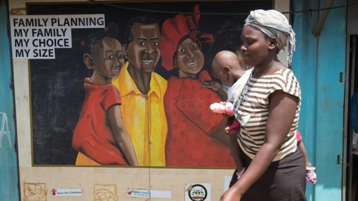 A woman walks past a mural on a Family Health Options clinic in the Kibera slums in Nairobi, Kenya, May 16, 2017. © 2017 Reuters