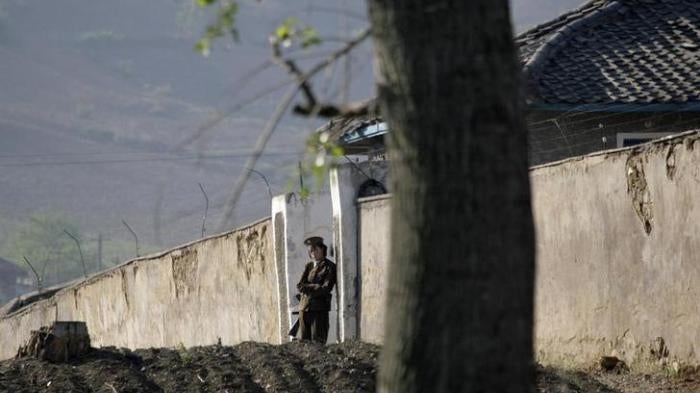 A North Korean soldier stands guard at the entrance of a women’s prison near Chongsong, North Korea, May 31, 2009.