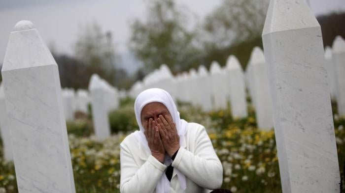 Mejra Dzogaz cries near the graves of her family members at the Memorial Center in Potocari, Bosnia and Herzegovina, 6 km north-west of Srebrenica, on April 7, 2014. Dzogaz lost her three sons, husband and father in the Srebrenica massacre. 
