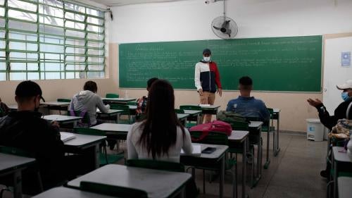 A teacher stands in front of a classroom of students