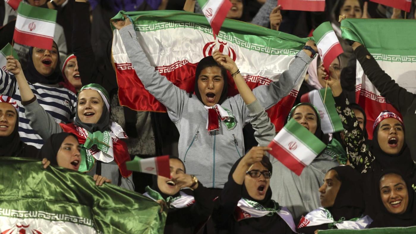 Female Iranian spectators cheer as they wave their country's flag during a friendly soccer match between Iran and Bolivia, at the Azadi (Freedom) stadium, in Tehran, Iran, Tuesday, Oct. 16, 2018.
