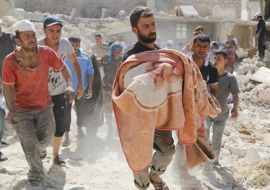 يبكي هؤلاء الأقارب بينما يحمل رجل جثة صبي ملفوفة ببطانية، في موقع قال نشطاء إنه استُهدف ببراميل متفجرة ألقتها طائرات القوات الموالية للرئيس بشار الأسد في منطقة الشيخ خضر، حلب، يوم 30 سبتمبر/أيلول 2014.  