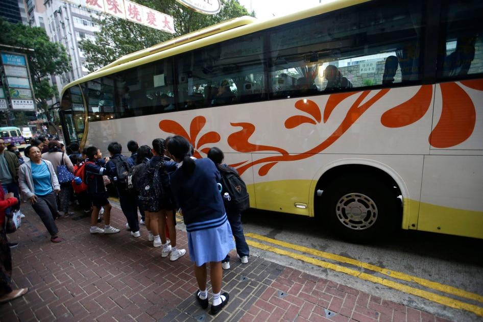 Children wait for a school bus in Hong Kong, November 20, 2019.