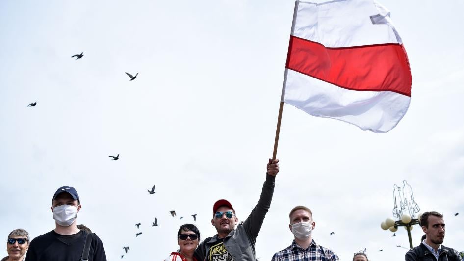 Протестующие размахивают бывшим национальным флагом Беларуси в Минске 7 июня 2020 года во время сбора подписей в поддержку оппозиционных кандидатов перед президентскими выборами 9 августа 2020 года.