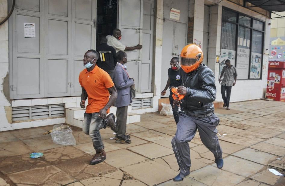 People in Uganda’s capital Kampala flee on November 18, 2020 during clashes between security forces and demonstrators protesting the arrest of opposition candidate Robert Kyagulanyi for allegedly breaching Covid-19 regulations by mobilizing large crowds for his campaign rallies.  