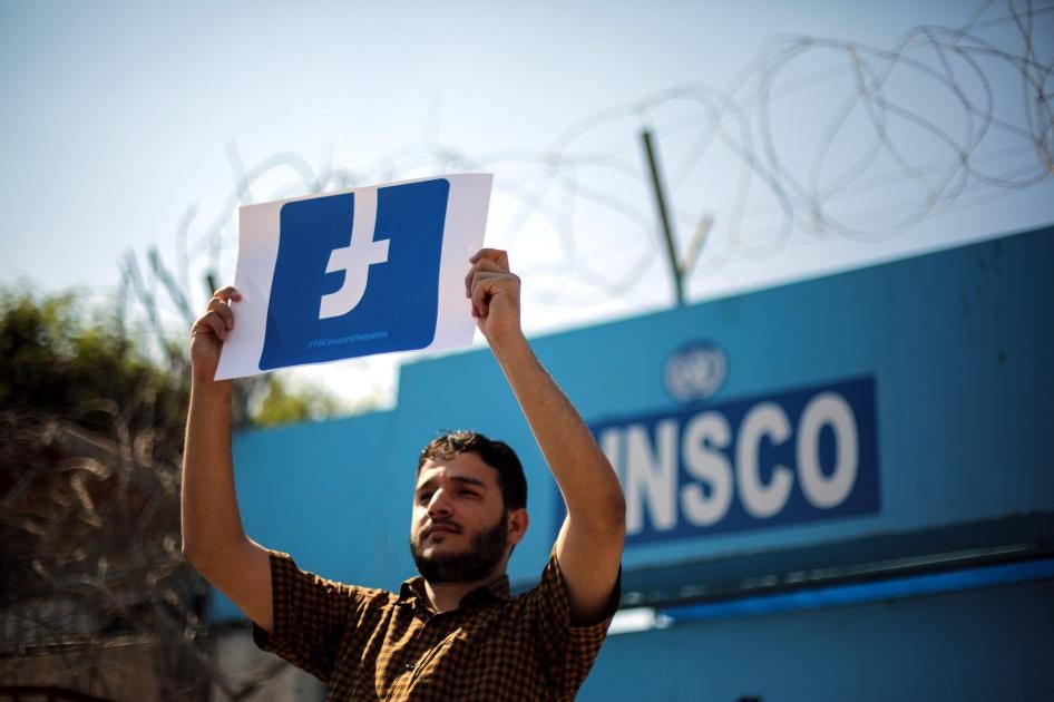 متظاهر فلسطيني يحمل لافتة عليها شعار "فيسبوك". 