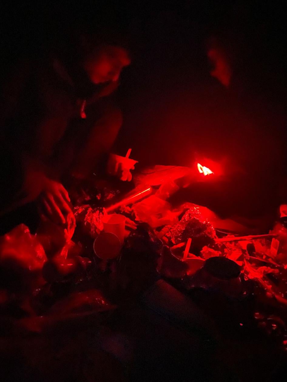 Migrants sit around a campfire at night