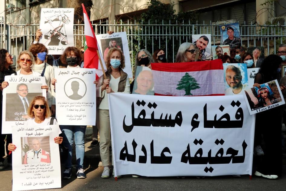 أهالي ضحايا إنفجار المرفأ يرفعون صور أحبائهم بالقرب من قصر العدل في بيروت في 25 نوفمبر/تشرين الثاني 2021. طالب الأقارب باستقلال القضاء لتحقيق العدالة.
