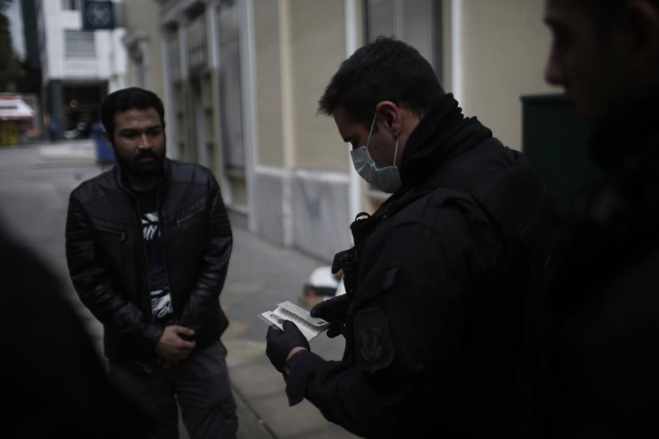 Αστυνομικοί ελέγχουν τα έγγραφα και τις άδειες ανθρώπων στους δρόμους της Αθήνας, Ελλάδα, 23 Μαρτίου 2020.