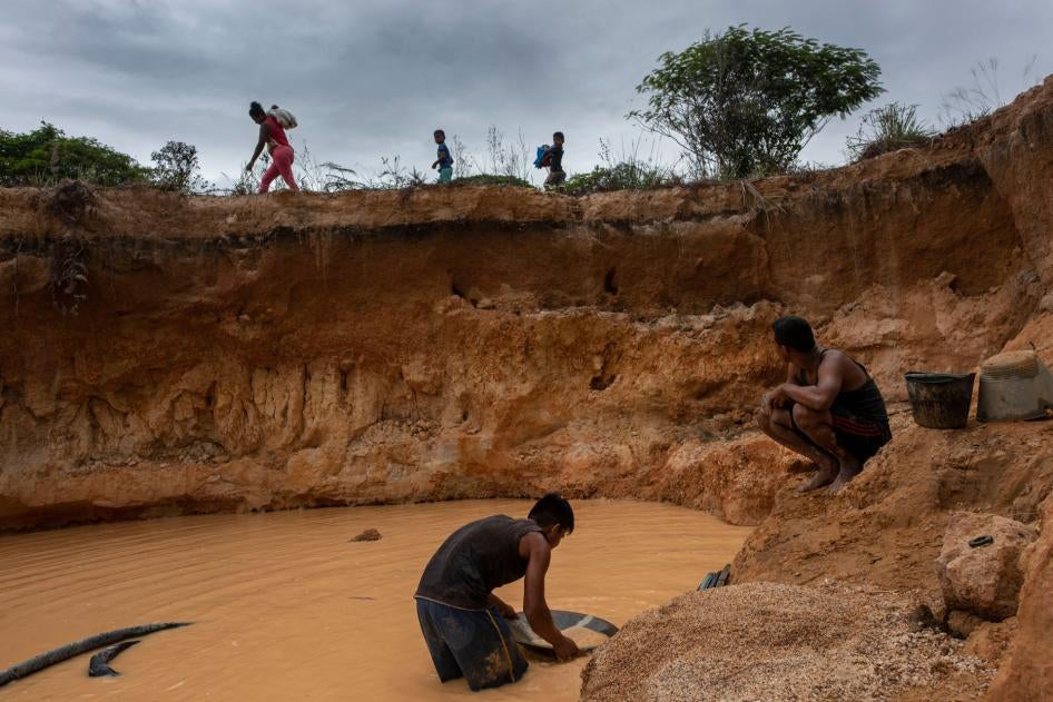 Men look for diamonds and gold in a recently dug mine