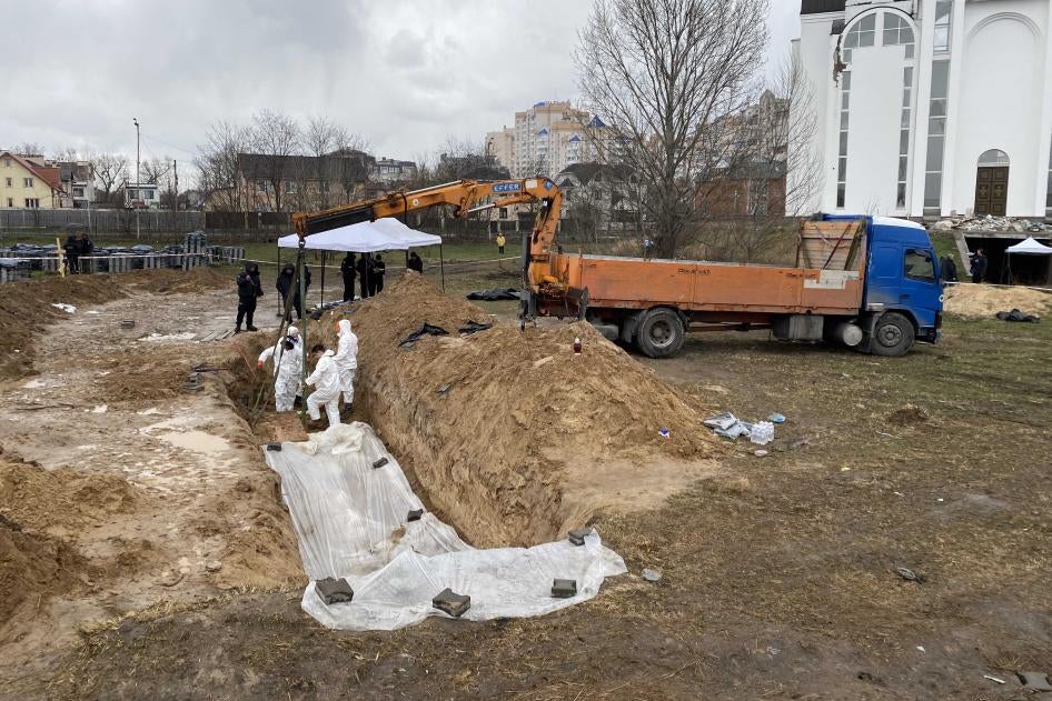 Ukrainian authorities in Bucha exhume bodies from a mass grave