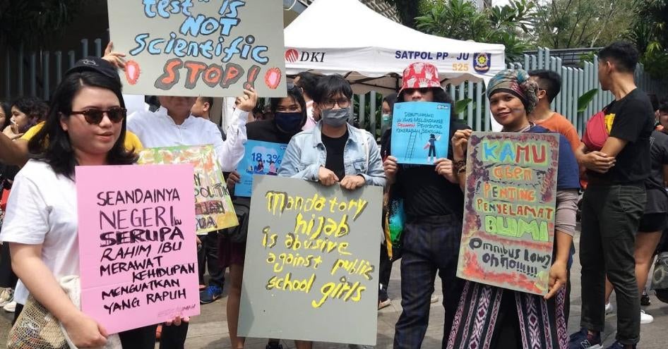 Protesters hold posters on various topics, including opposing mandatory hijab requirements for girls in state schools, during the Women’s March in Jakarta, March 2020.