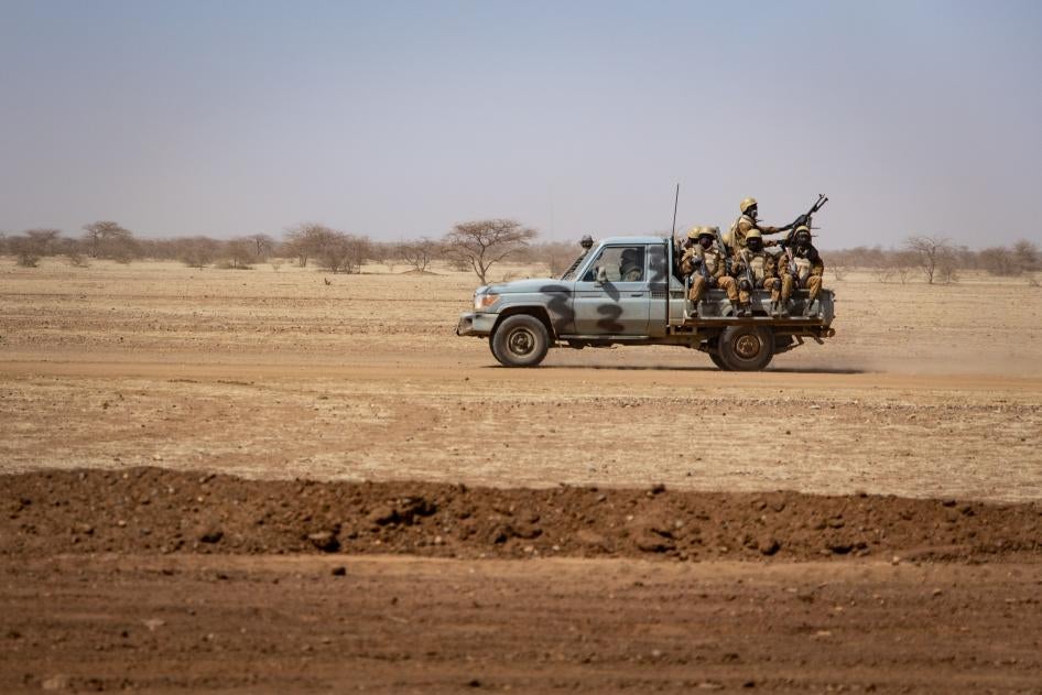 Des soldats burkinabè patrouillaient à bord d'un pick-up sur la route reliant la ville de Dori au camp de réfugiés de Goudebo, au Burkina Faso, le 3 février 2020. 