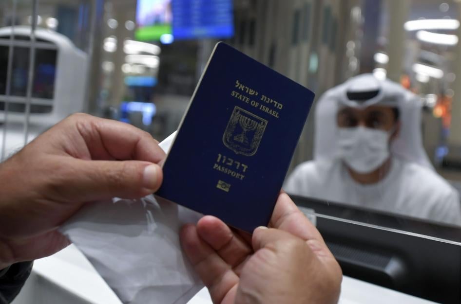 גבר ישראלי מציג את דרכונו לבדיקה עם הגעתו מתל אביב לנמל התעופה בדובאי שבאיחוד האמירויות הערביותב-23 בנובמבר 2020. 