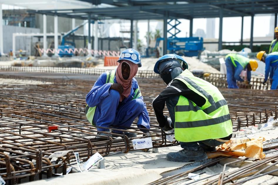 Deux travailleurs migrants accroupis sur un chantier à Dubaï, Émirats arabes unis, le 15 août 2023. Les Émirats arabes unis ont commencé à mettre en place une pause de travail entre 12h30 et 15h30 sur de tels chantiers, en raison de la forte chaleur.
