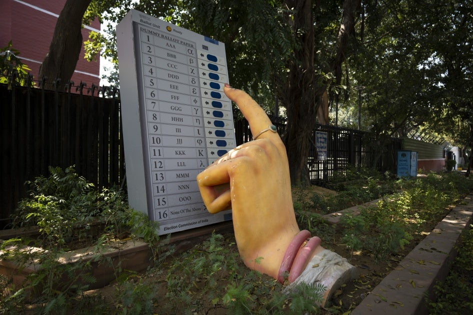 A model of a woman's finger pressing the button of an electronic voting machine