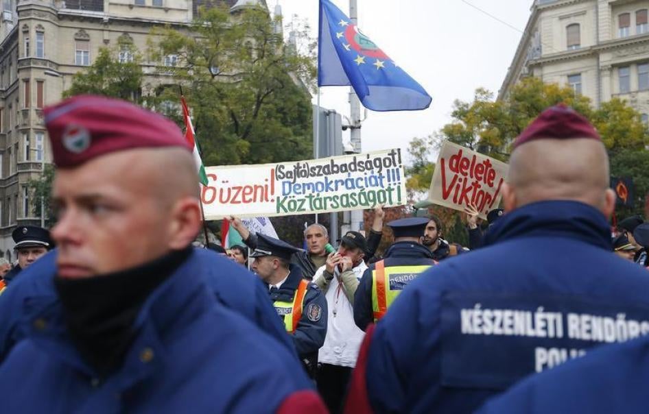 Hungarian police stand guard in front of anti-government protesters near to a ceremony marking the 60th anniversary of 1956 anti-Communist uprising in Budapest, Hungary, October 23, 2016.