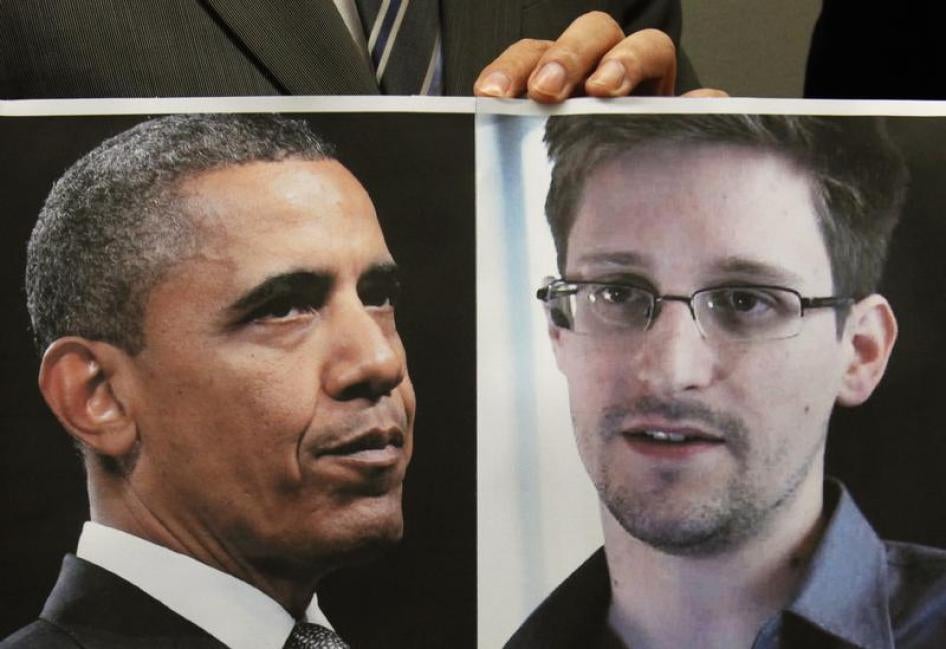 Um apoiador de Edward Snowden segura uma combinação de fotos com o presidente dos EUA, Barack Obama, e Edward Snowden, durante uma conferência de imprensa em Hong Kong. 14 de Junho de 2013.