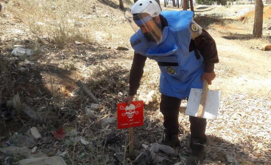 Técnico treinado da Defesa Civil Síria (“capacetes brancos”) identifica e marca submunição intacta e outros remanescentes de explosivos da guerra para limpeza e destruição em Idlib em 8 de Junho de 2017.