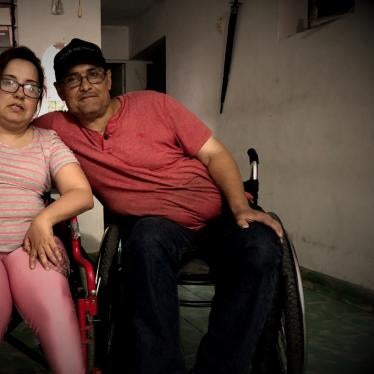 A man and woman pose in wheelchairs