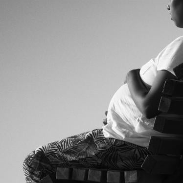 A pregnant African-American woman sits on a bench in a black and white photo