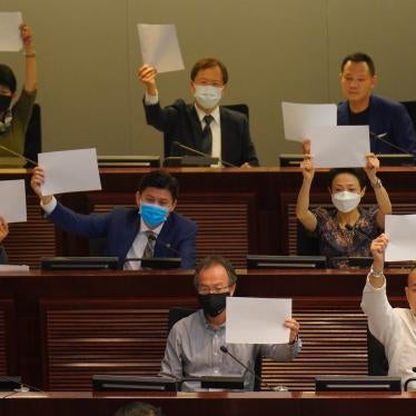 Pro-democracy lawmakers raise white papers to protest during a meeting to discuss the new national security law at the Legislative Council in Hong Kong, July 7, 2020. © 2020 AP Photo/Vincent Yu
