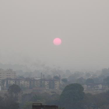 The sun rises over a city skyline covered in smoke