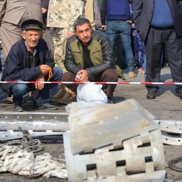 Residents of Barda examine the remnants of a Smerch cluster munition rocket 