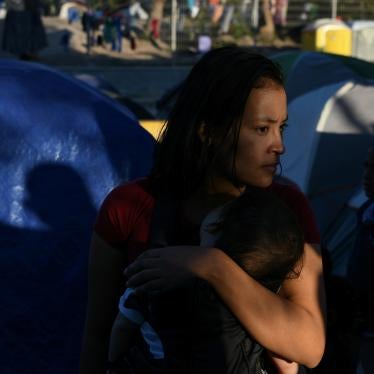A Honduran migrant mother and child wait in line for a dinner provided by volunteers at a makeshift encampment occupied by asylum seekers sent back to Mexico from the US in Matamoros, Tamaulipas, Mexico, October 27, 2019.  