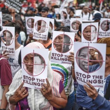 Protesters hold up pictures of victims of extrajudicial killings during Human Rights Day protests in Manila