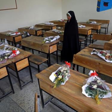 The mother of a schoolgirl who was among those killed in the brutal May 8, 2021 bombing of the Sayed ul-Shuhada girls' school stands inside a classroom with bouquets of flowers on empty desks as a tribute to the dead, in Kabul, Afghanistan, May 16, 2021. 