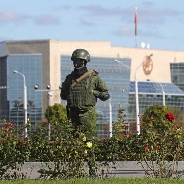 A riot police officer guards the area in State Flag Square, Minsk, Belarus, with the Supreme Court building in the background.